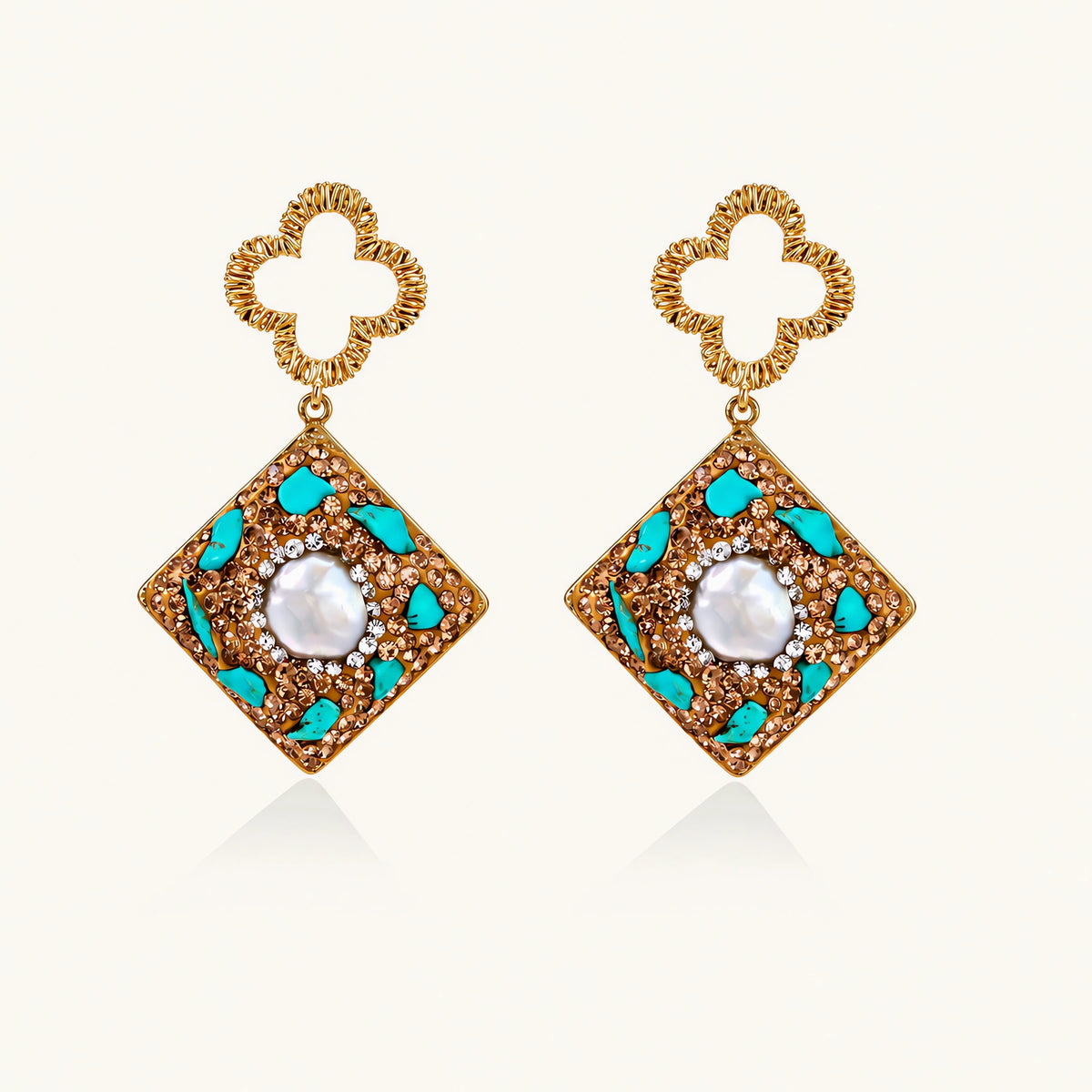 Gold-plated drop earrings with quatrefoil studs, diamond-shaped pendants featuring baroque pearls, turquoise stones, and amber crystals