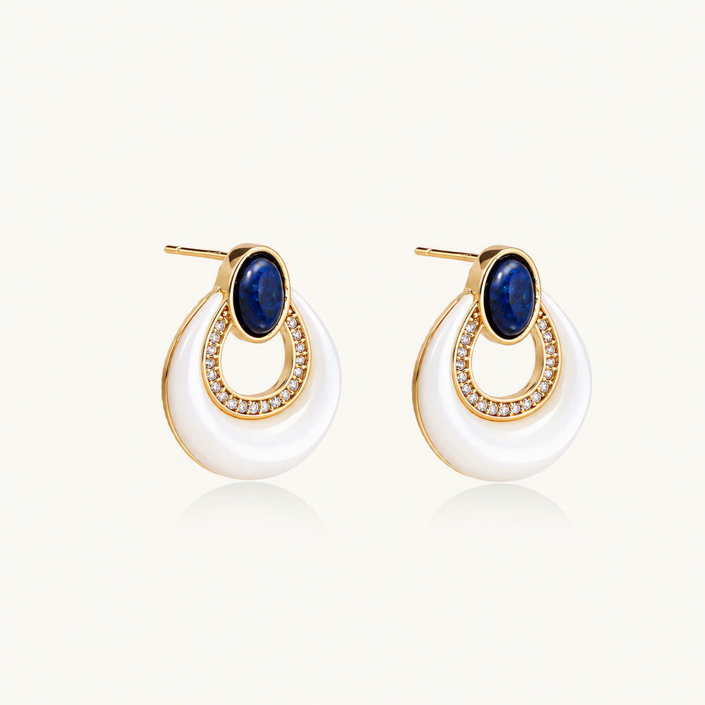 Gold plated stud earrings with an oval lapis lazuli top, CZ-lined teardrop loop and white MOP crescent on a cream background.