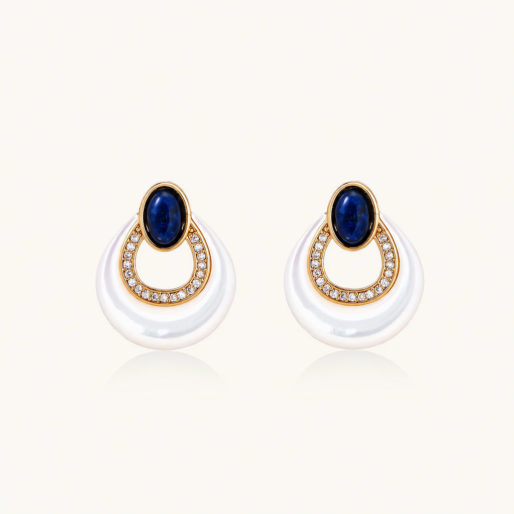 Gold plated stud earrings with an oval lapis lazuli top, CZ-lined teardrop loop and white MOP crescent on a cream background.