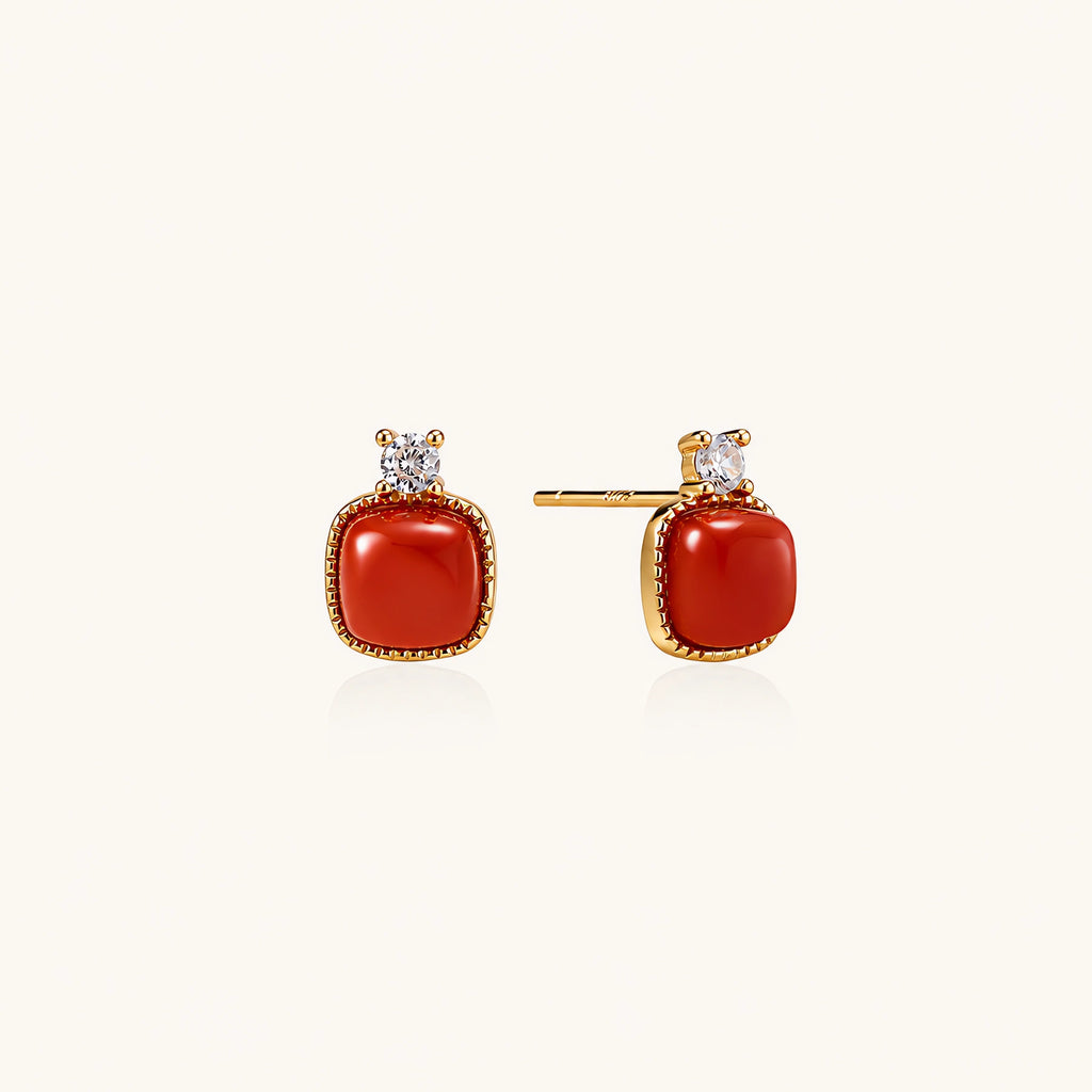 18K gold vermeil stud earrings with cushion-cut red agate stones and sparkling crystal accents on beige background