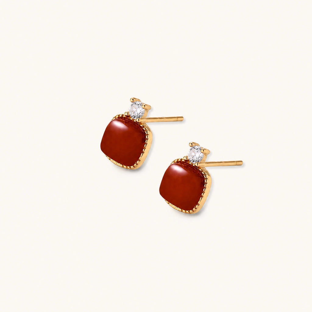 18K gold vermeil stud earrings with cushion-cut red agate stones and sparkling crystal accents on beige background