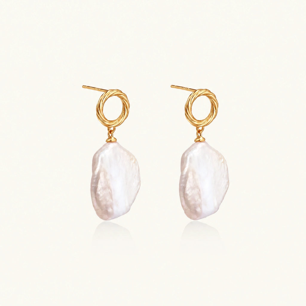 18K gold vermeil twisted circle studs with organic white baroque pearl drops on cream background