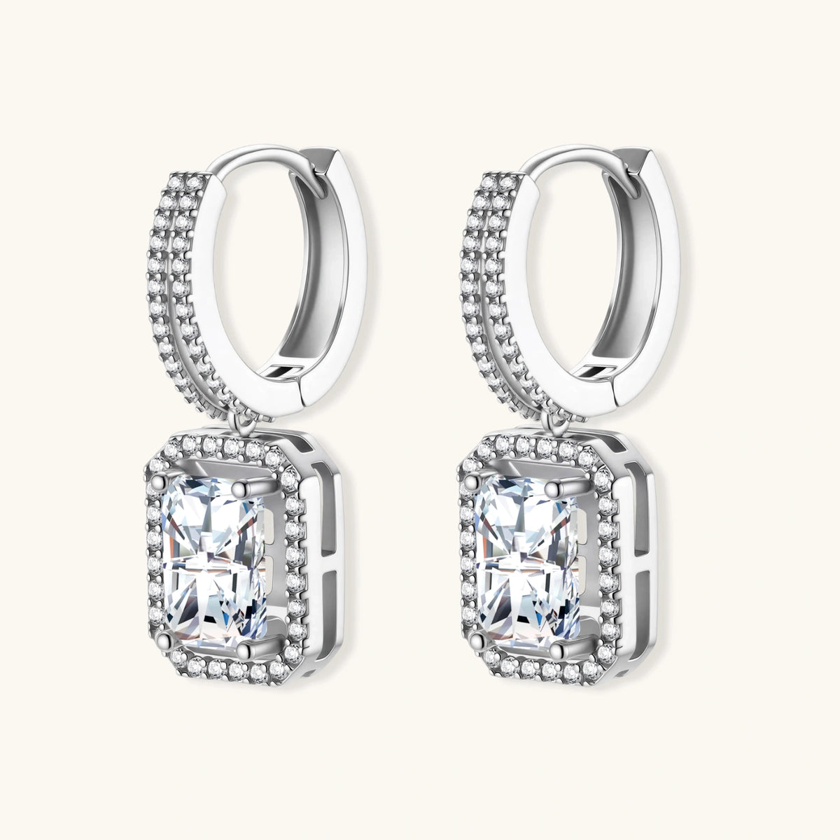 Sterling silver huggie hoops with emerald-cut moissanite drops featuring pavé-set crystals on white background.