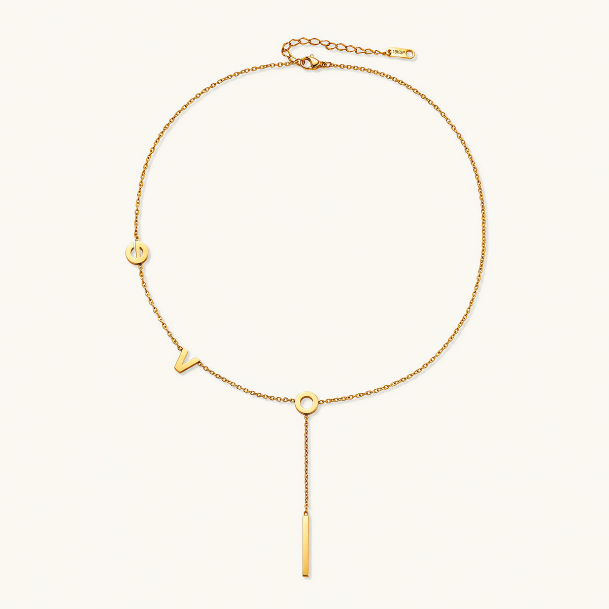 Gold Y-shaped necklace with L-O-V-E letter charms and vertical bar pendant on delicate chain against cream background