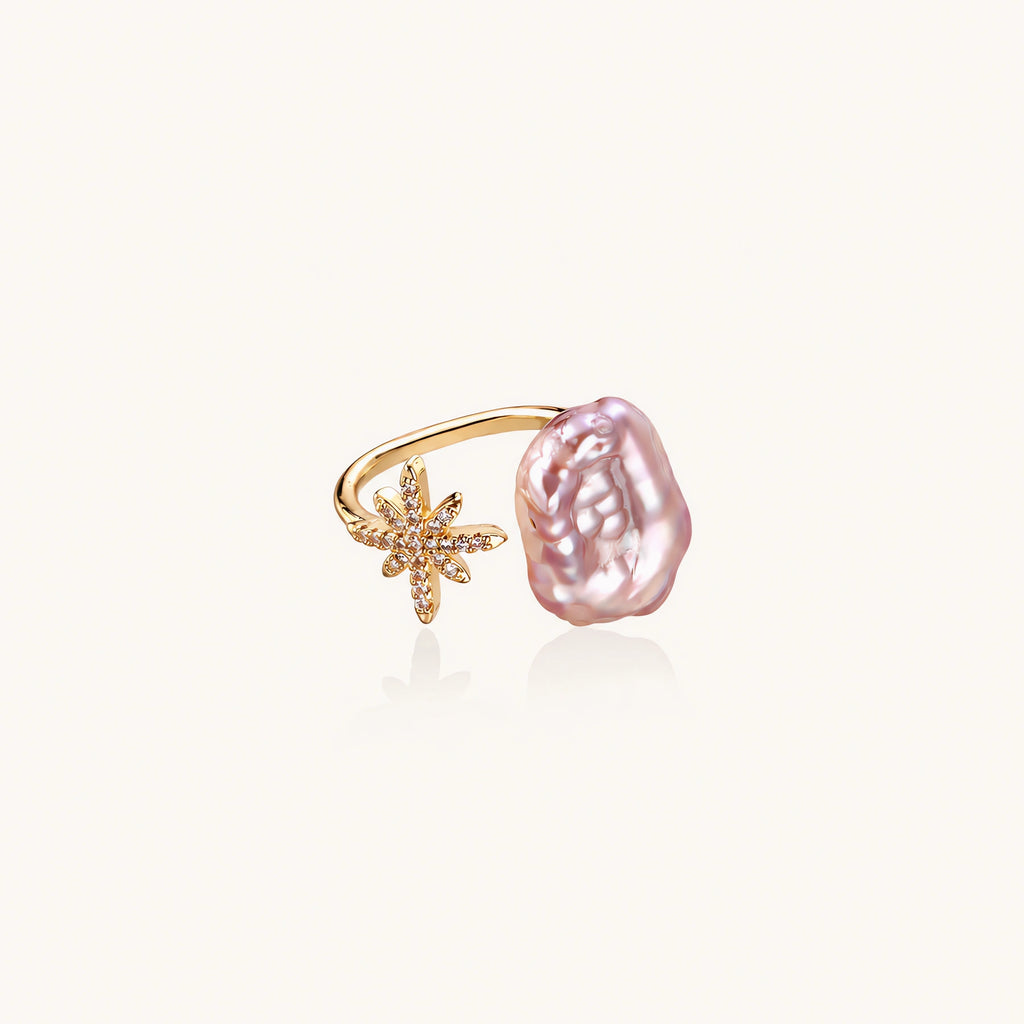 Adjustable gold ring with pink baroque freshwater pearl and crystal-studded star charm on white background