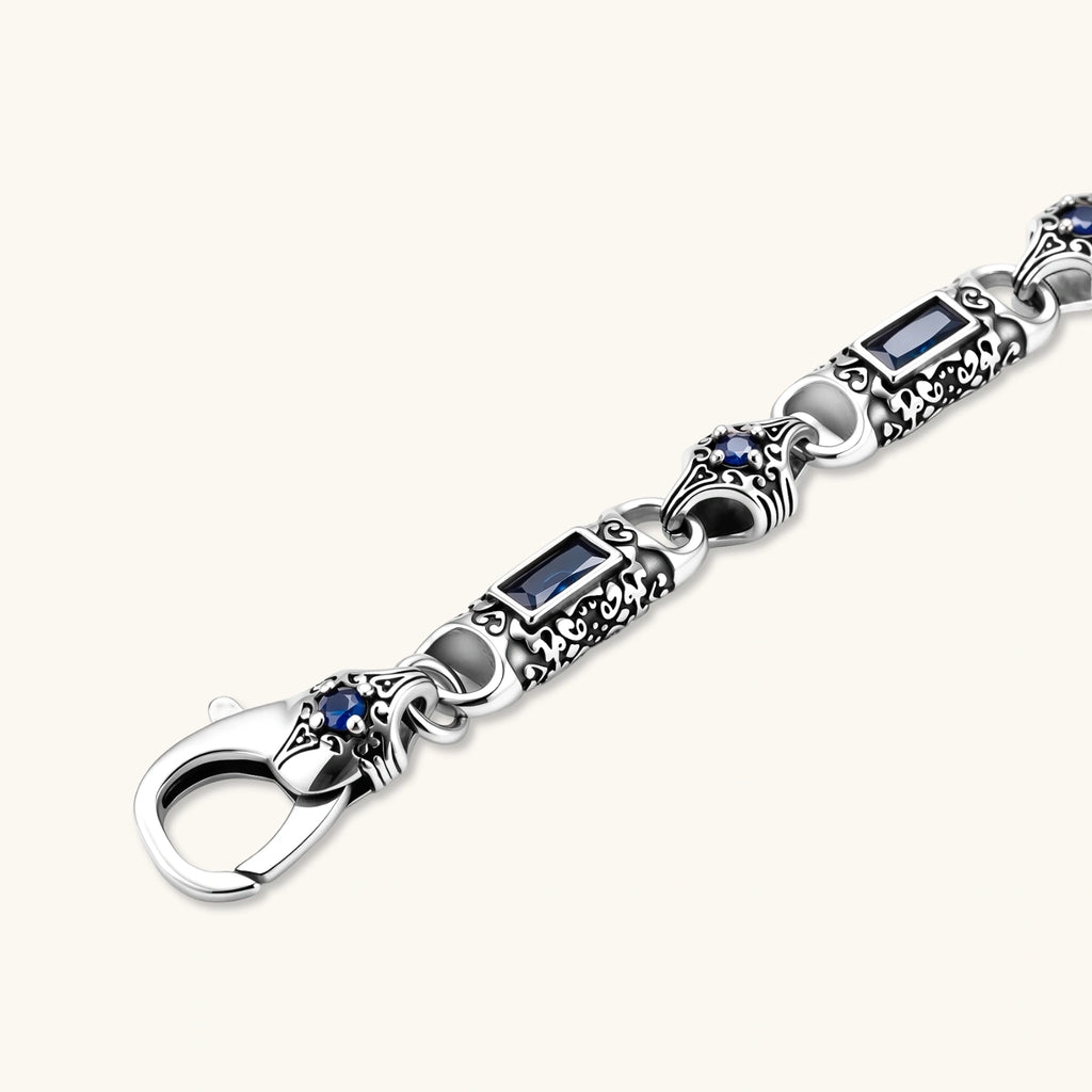 Antique silver plated eco-brass link bracelet with engraved scrollwork, blue baguette cubic zirconia and a lobster clasp.