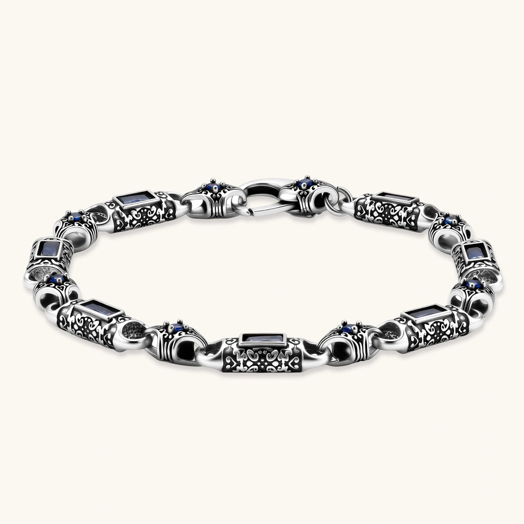 Antique silver plated eco-brass link bracelet with engraved scrollwork, blue baguette cubic zirconia and a lobster clasp.