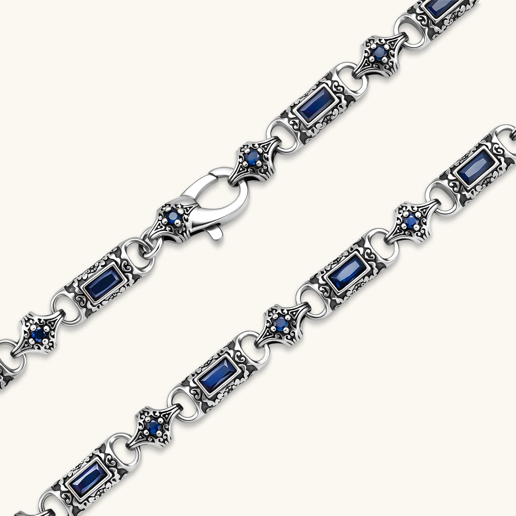 Antique silver plated eco-brass link necklace with blue baguette and round cubic zirconia in ornate scrollwork settings.