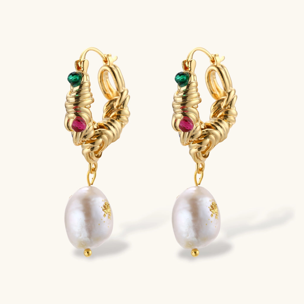 Pair of gold twisted-rope hoop earrings with green, pink and blue beads and baroque freshwater pearl drops on a cream background.
