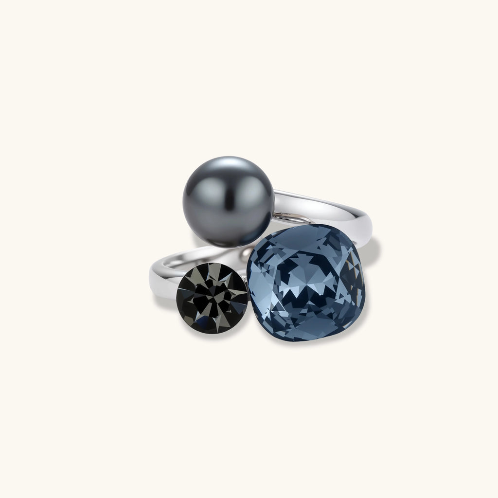 White gold plated eco-brass bypass ring with a large denim-blue cushion stone, a small smoky gray round stone and a dark gray bead.